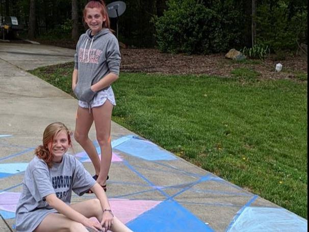 Photo of teens working on chalk art in driveway