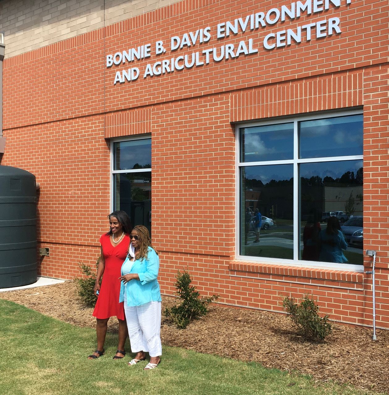 Bonnie B. Davis family members standing in front of building sign