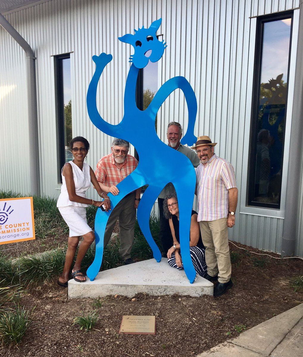 Photo of some county commissioners and the artist posing with Calypso Cat sculpture 