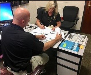 Detectives Tim Horne and Dawn Hunter look over evidence.