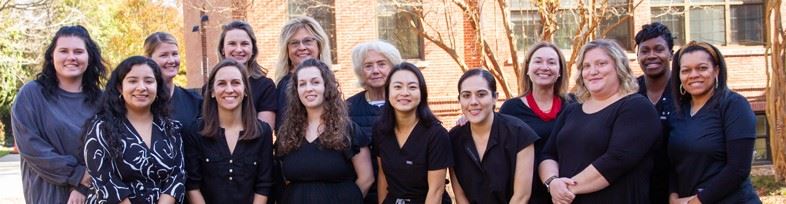 Dental health staff smiling outside the clinic