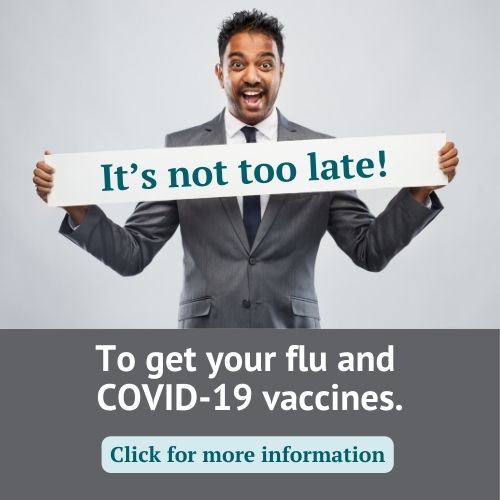 guy holding banner reading It's not too late, advocating for flu and COVID vaccines.