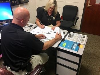 Detectives Tim Horne and Dawn Hunter look over evidence.